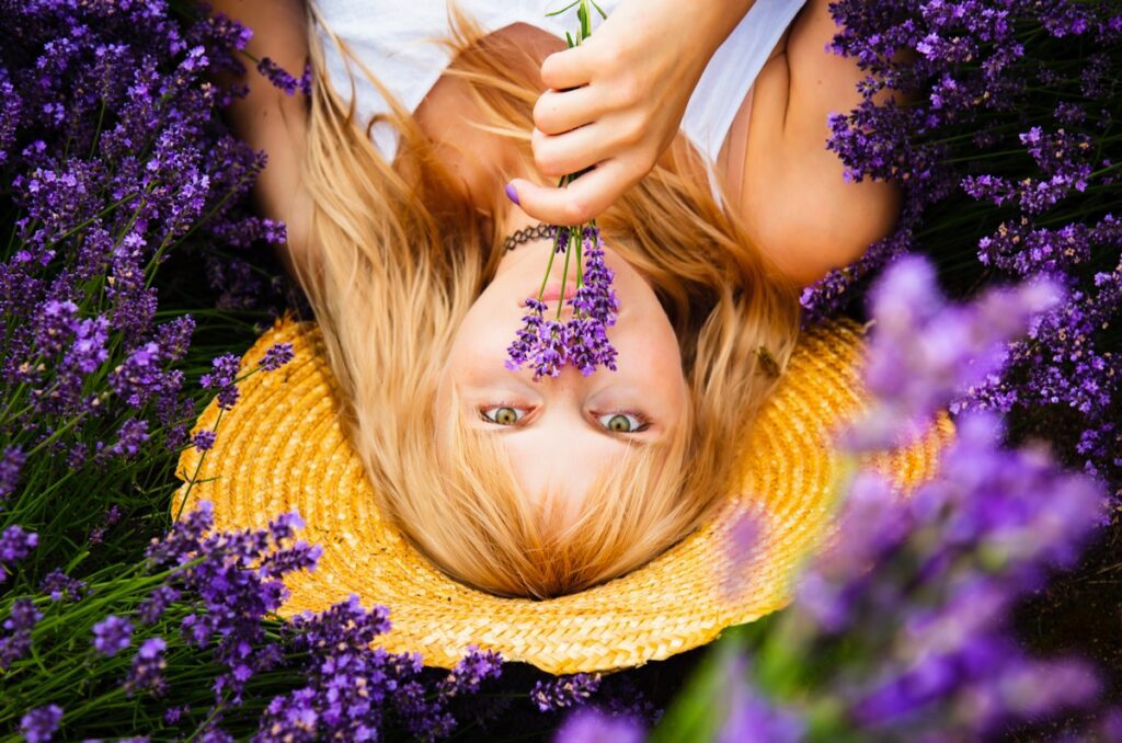 Beautiful woman with blond hair is lying down in lavender flower