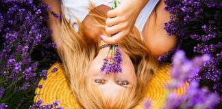 Beautiful woman with blond hair is lying down in lavender flower