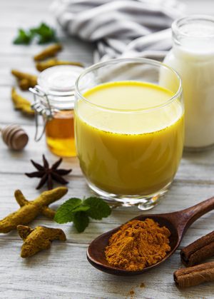 Yellow turmeric latte drink. Golden milk with cinnamon, turmeric
